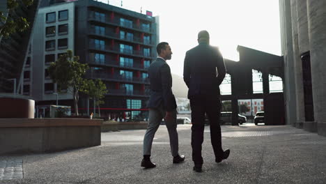 businessmen walking and talking in a city