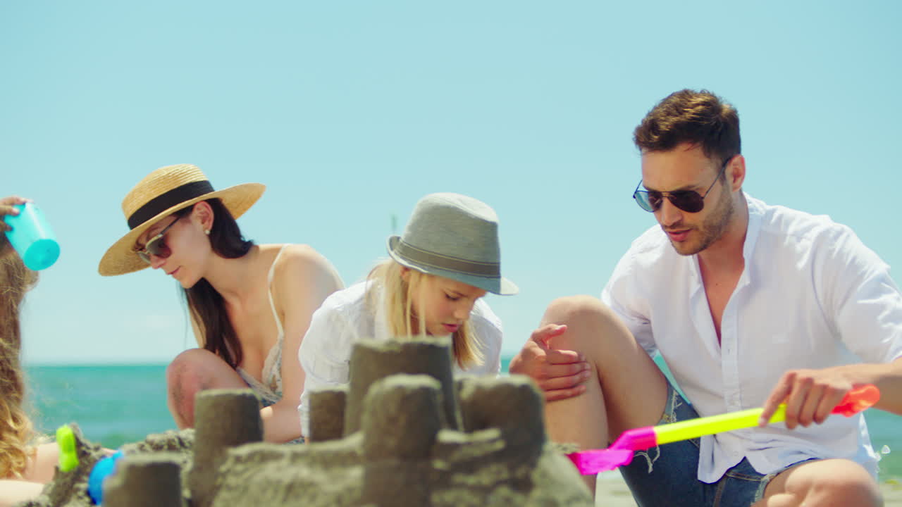 해변에 모래 성을 짓는 가족