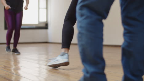 Close-up-shot-of-group-of-people-rehearsing-dance-combination