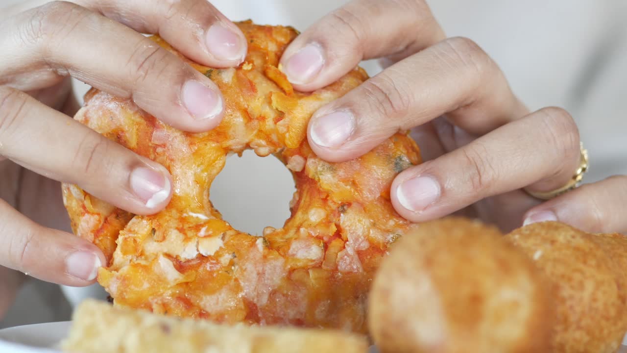 Close up of hands eating a donut