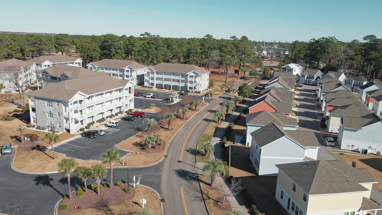 vuelo descendente aéreo sobre la calle con casas de nueva construcción en el distrito de myrtle beach durante el día de verano
