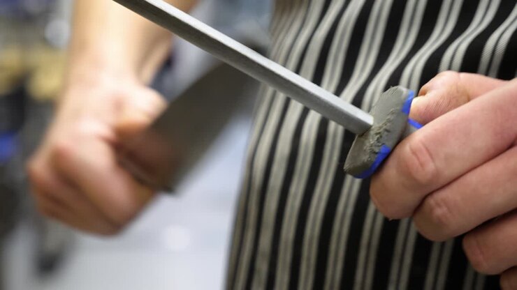 Chef sharpening his knife in professional setting