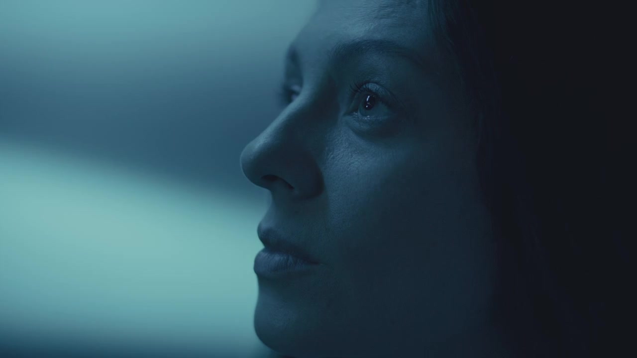 Primo piano di donna che guarda in alto attraverso una foschia blu