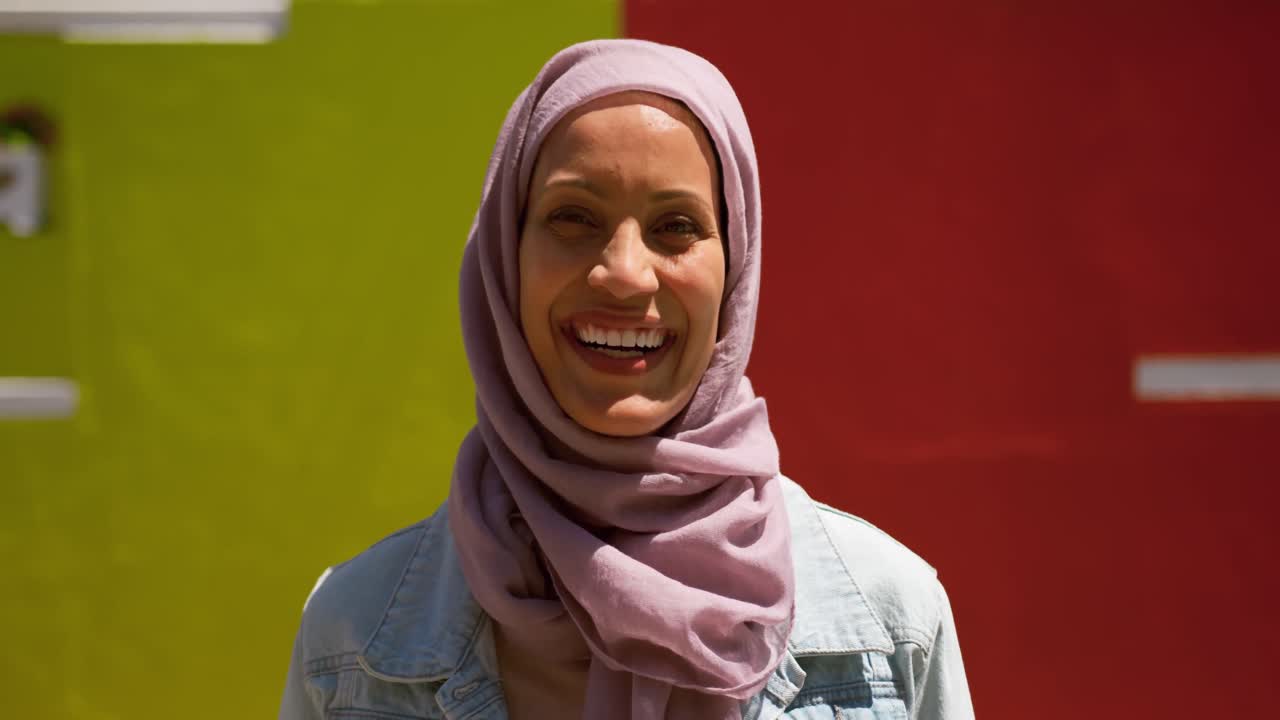 히자브를 입은 젊은 여성이 도시를 돌아다니고 있습니다.