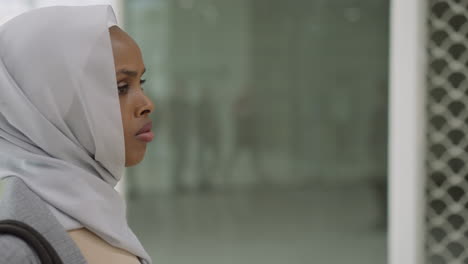 Thoughtful-black-lady-with-hijab-on-head-in-shopping-center