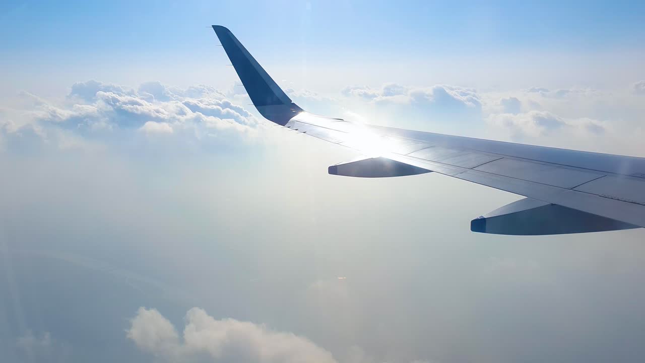 曇り空の上を通過する商用航空機の翼の窓からの眺め