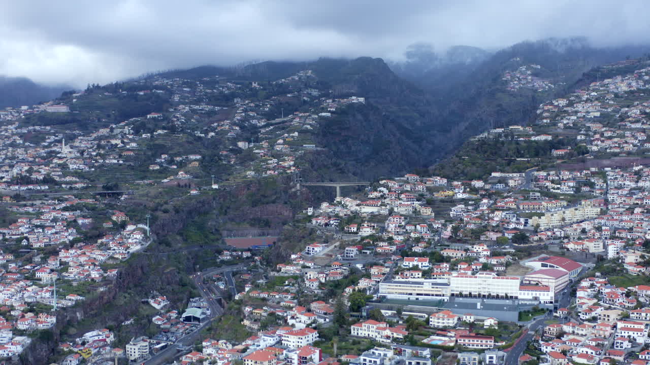 imágenes aéreas de drones de la ciudad de funchal con colinas de madeira en el fondo