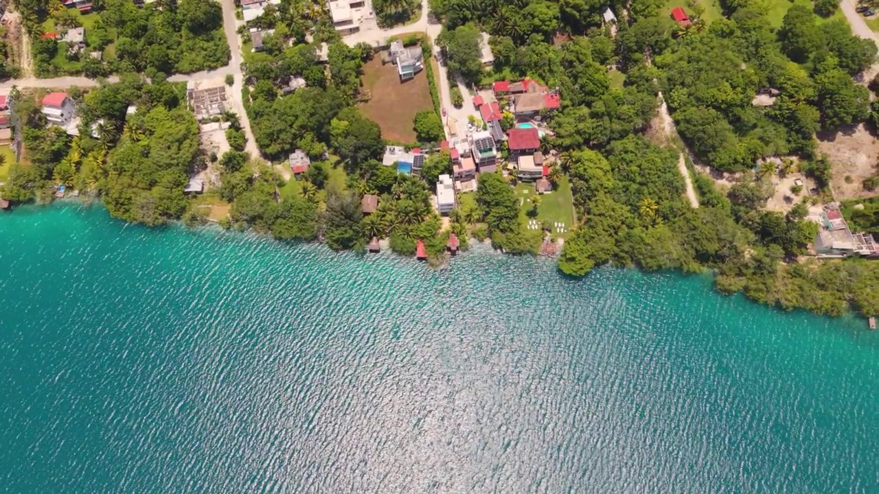 Veduta aerea soleggiata che rivela le vivaci acque turchesi della Laguna Xul-Ha.