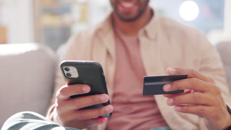 tarjeta de crédito, teléfono y manos de hombre en una sala de estar