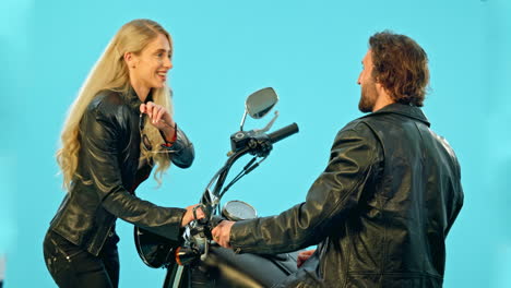 coqueteo, motocicleta y pareja en fondo azul