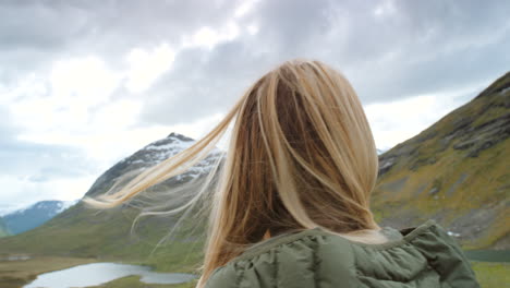 woman enjoying the view of mountains and lake in norway