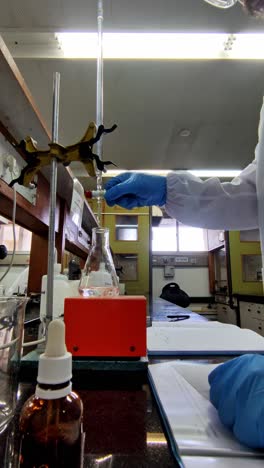 lab worker adjusting burette clamp setup