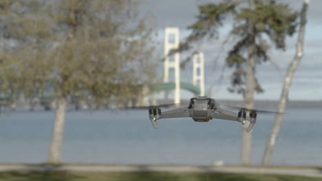 drone flying in the foreground with the mackinac bridge in michigan in the background