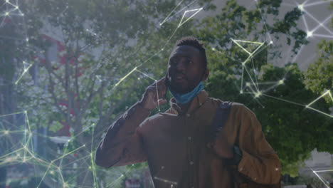 animation of networks with businessman i face mask talking on smartphone in street