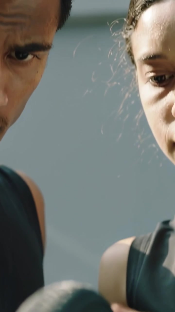 Video verticale: Mano che afferra una corda in movimento in un duo in palestra che controlla le fibre per l'allenamento con canotte nere.