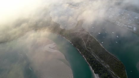 Vista-Aérea-A-Través-De-Las-Nubes-De-La-Playa-Principal-De-Noosa-Heads-Y-Los-Jardines-Botánicos-De-Noosa-En-Queensland,-Australia