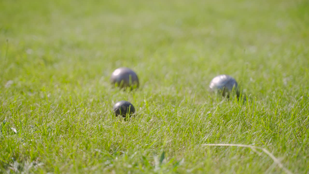 vista lateral de las bolas de pentanca en el césped del parque