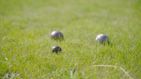 seitenansicht von pentanque-kugeln auf dem rasen im park