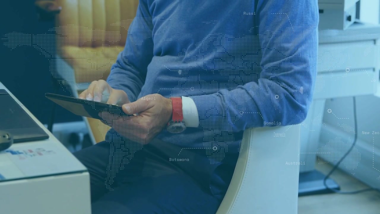 Vertical video: Reacting to map overlay, man in blue sweater tapping and tilting tablet at desk