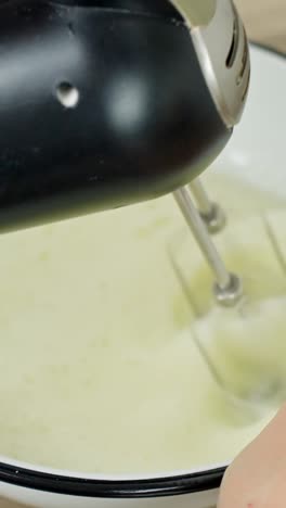 vertical close-up of egg whites whipped with electric mixer for tiramisu prep