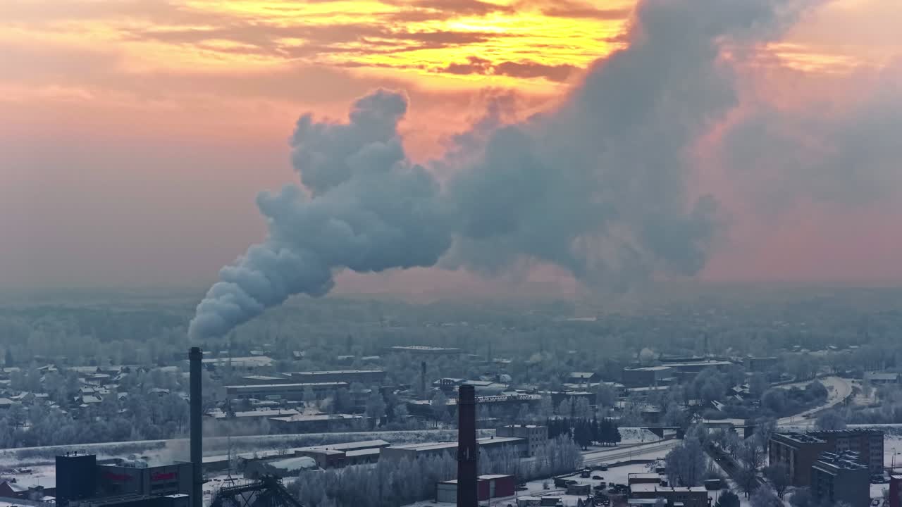 Inquinamento atmosferico industriale. Pennacchio di fumo che si alza da una ciminiera in una fabbrica chimica durante il tramonto. Ripresa aerea.