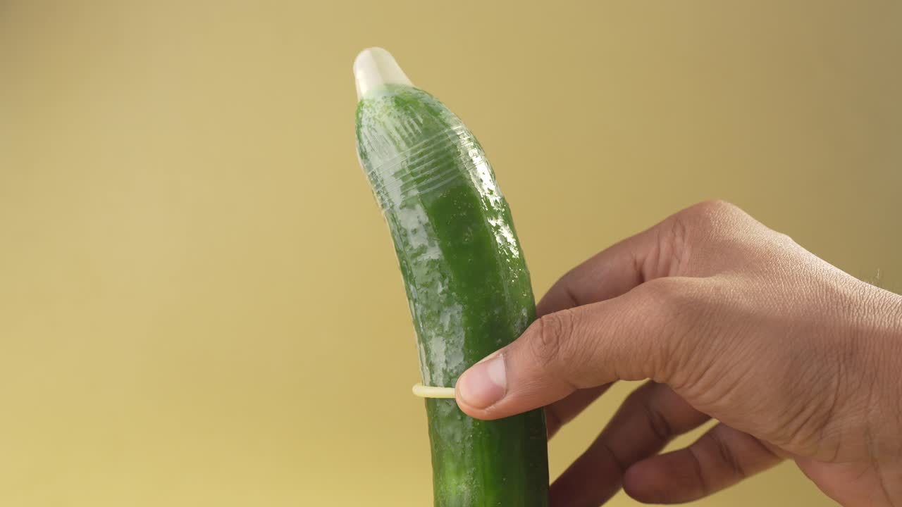 Dimostrazione di come si usa un preservativo, infilandolo su un cetriolo