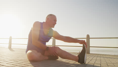 Senior-man-stretching-his-legs-on-the-promenade