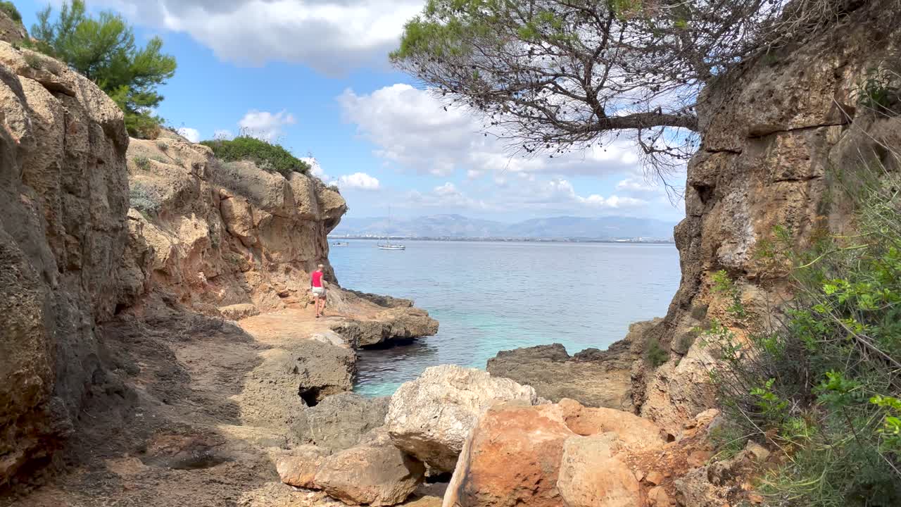 Donna esplora una zona di scogliere in riva al mare, Bella Vista, Maiorca, Spagna