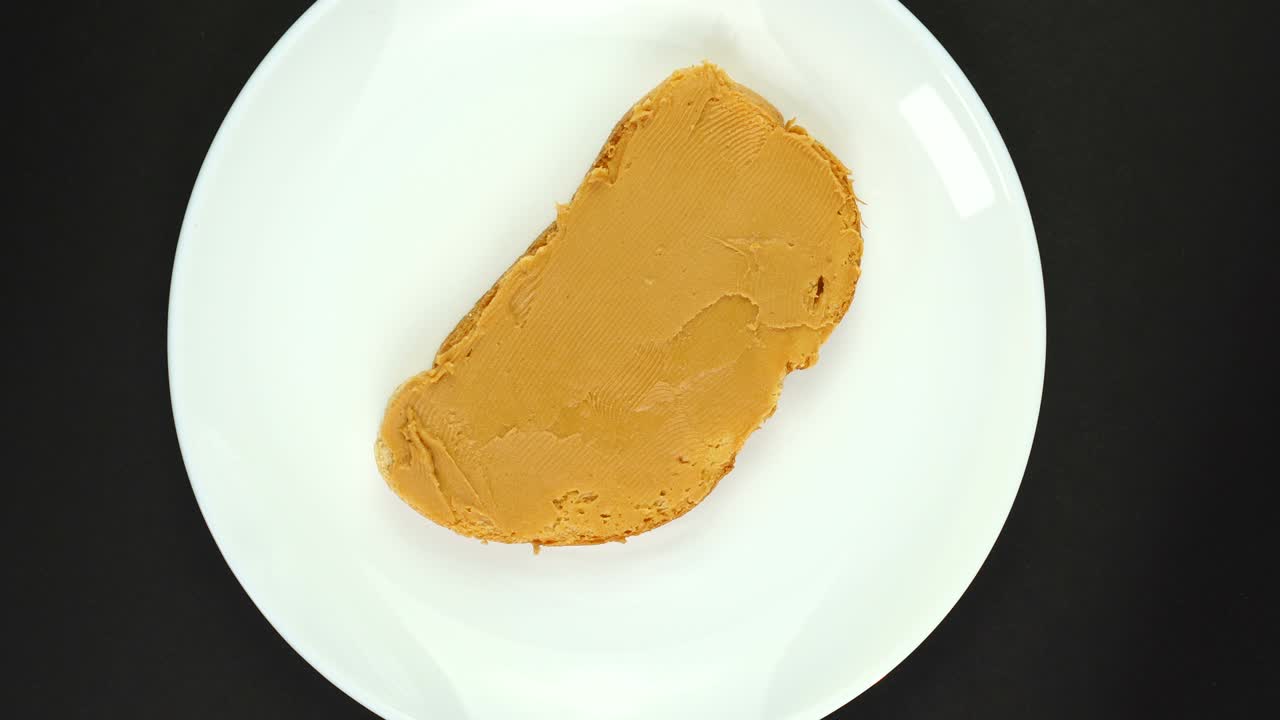 Rotation of a peanut butter sandwich isolated on black. 360 degree rotation.