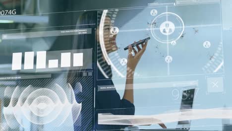 animation of data processing against biracial businesswoman talking on smartphone at office