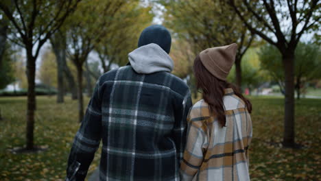 una pareja enamorada caminando en el parque de otoño durante el día.