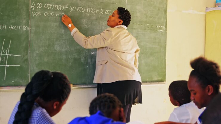 Female teacher at the blackboard in front of class 4k