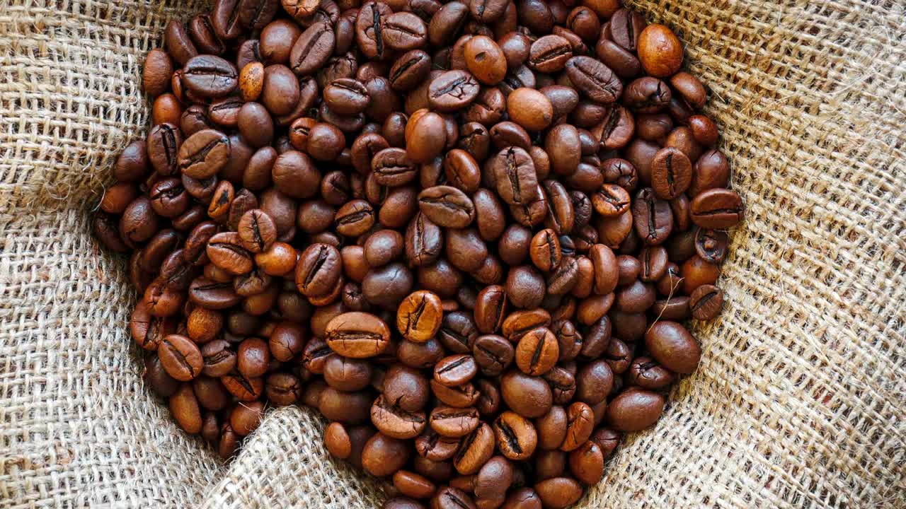 Chicchi di caffè tostati su sfondo di iuta.