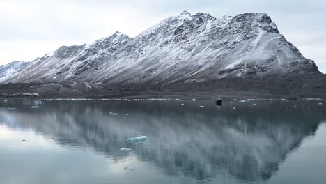 reflections of a mountain by a glacier in the arctic sea