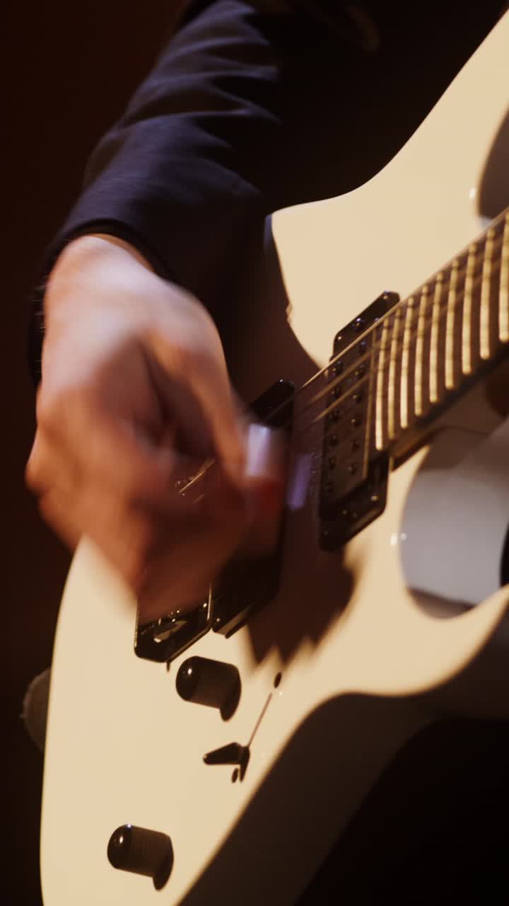persona tocando una guitarra eléctrica blanca