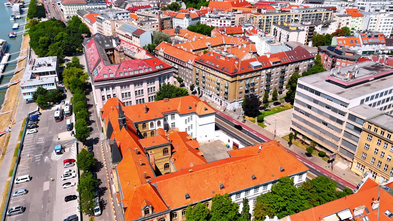 Beautiful old buildings with orange roofs at the waterfront of the Danube. Long riverboats are at the coast. Old town in Bratislava, Slovakia