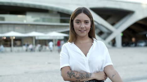 una mujer alegre con una blusa blanca mirando a la cámara
