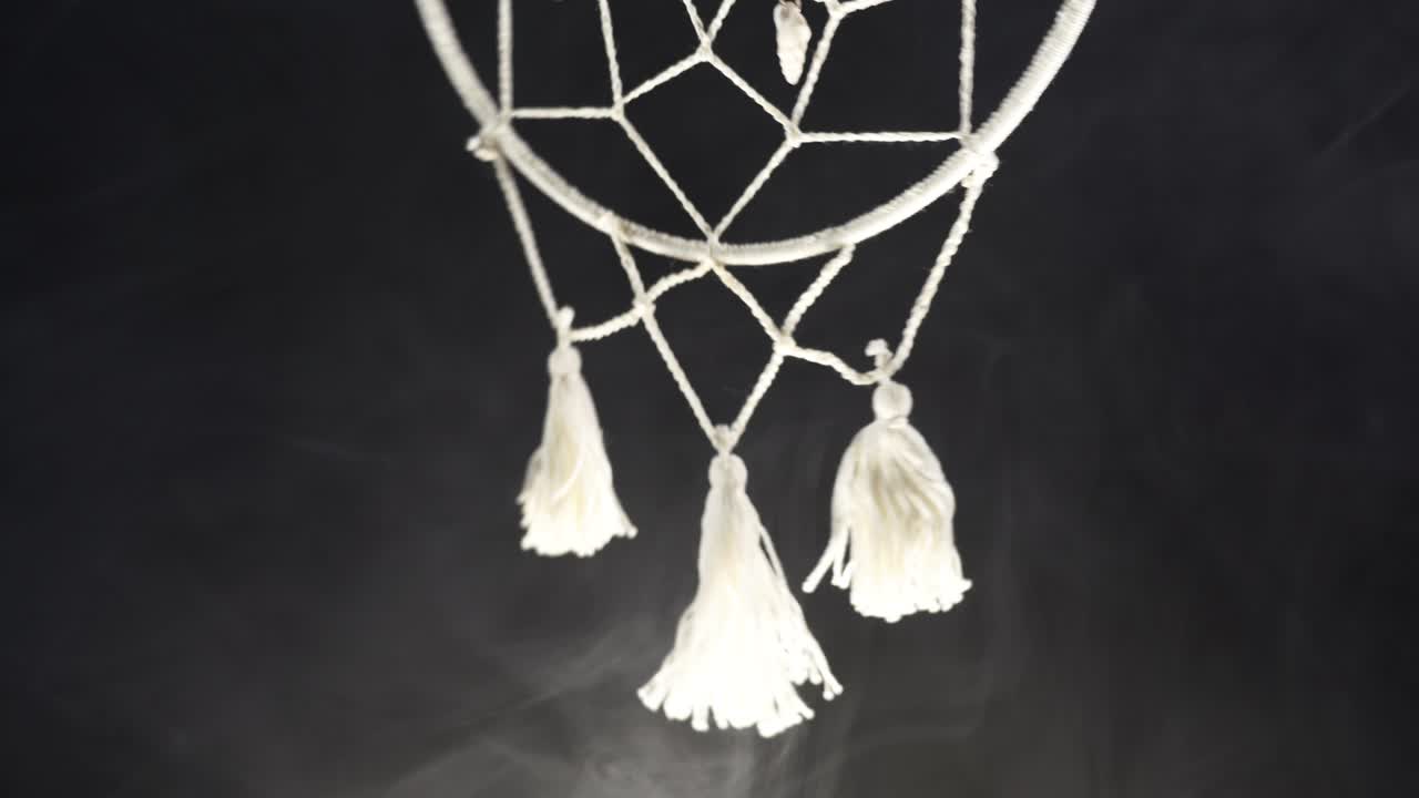 흑색 배경과 연기가 있는 신비로운 속성 드림캐처