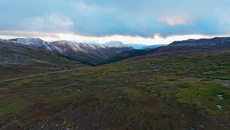 scenic drone shot at sunset over snow-capped mountains and valleys in independence pass, colorado