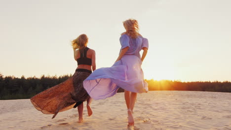 Two-Women-In-Luz-Dresses-Run-Toward-The-Sun-Concept-Women\'s-Dreams-Health-Happiness-Steadicam-Slow