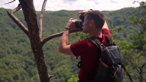 Happy-landscape-photographer-following-his-dream-takes-a-photo-of-nature-with-his-DSLR-camera---revolving-shot