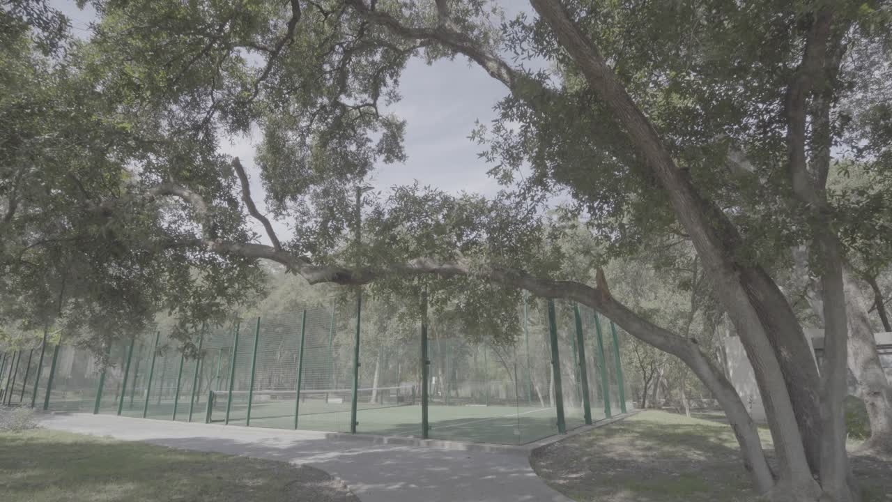 Slow dolly shot towards a paddle court in the garden of a millionaires villa