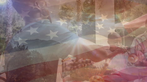 animation of flag of usa over african american family eating dinner in garden
