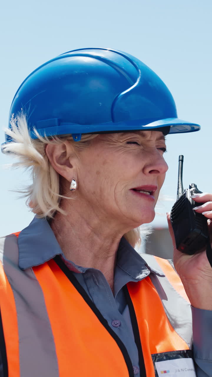 Donna matura con cappello che comunica con un walkie-talkie