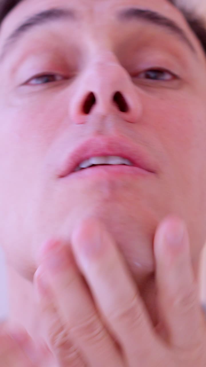 Man applying cream on his face and cocoa on lips