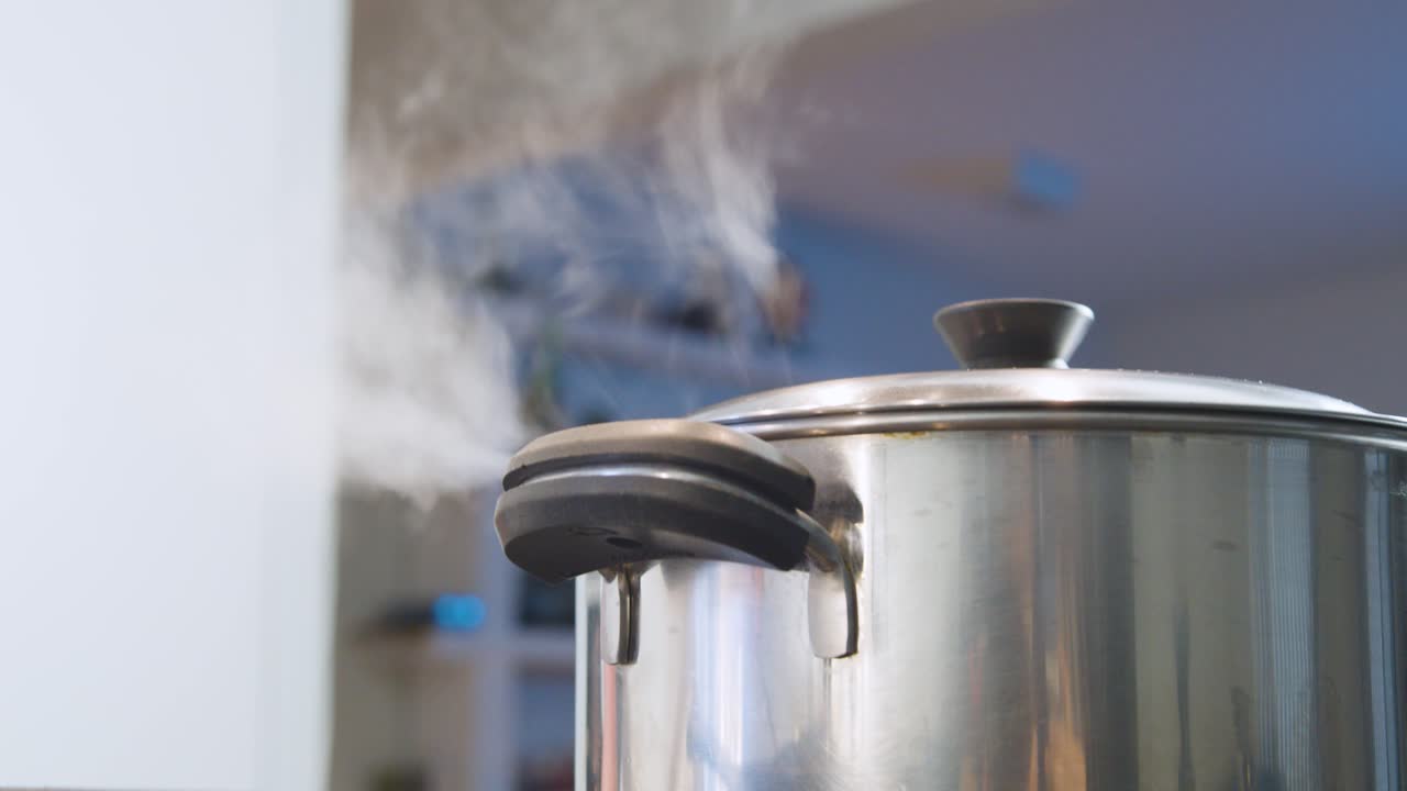 Close up and focus on foreground on steaming pot. Low angle and static shot