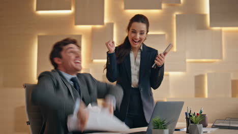 Couple businesspeople celebrating victory in office closeup. Partners rejoicing