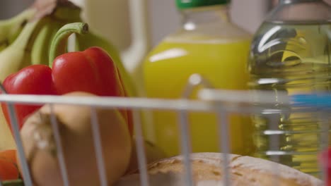 primer plano de la persona que toma alimentos básicos de la cesta de la compra del supermercado 1