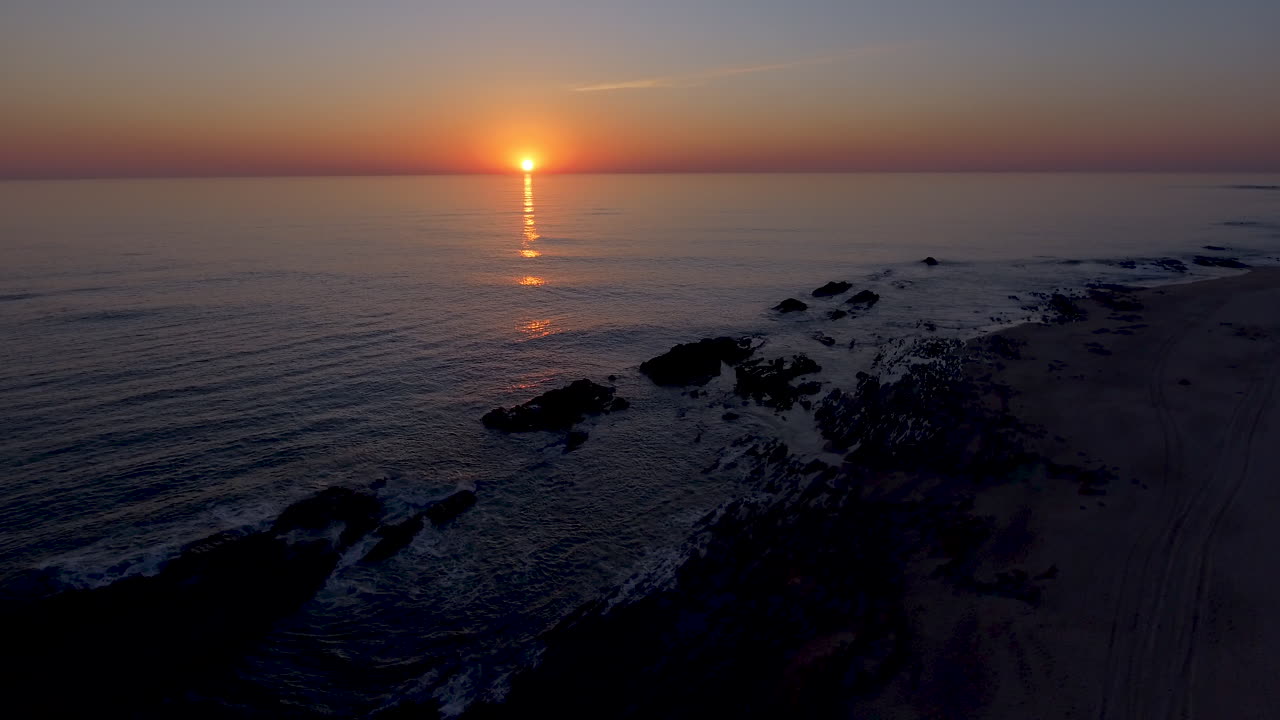 toma aérea descendente de pedestal de 4k de la hermosa costa del mar al atardecer