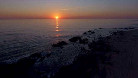 Toma-Aérea-Descendente-De-Pedestal-De-4k-De-La-Hermosa-Costa-Del-Mar-Al-Atardecer